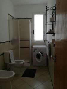 a bathroom with a toilet and a washing machine at Casa Sara Boavista in Sal Rei