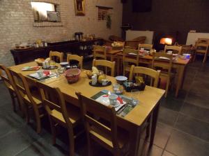 une salle à manger avec des tables et des chaises en bois dans l'établissement B&B De Linde, à Wijtschate