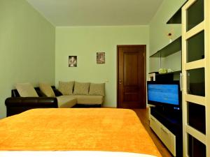 トゥーラにあるInndays on Micheeva 25のベッド、ソファ、テレビが備わる客室です。