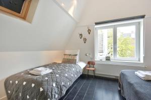アムステルダムにある2 BEDROOM CITY CENTER TERRACEのベッドルーム1室(ベッド2台、窓付)
