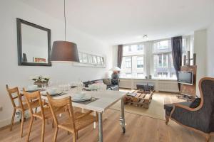 a living room with a table and chairs and a living room at 2 BEDROOM CITY CENTER TERRACE in Amsterdam