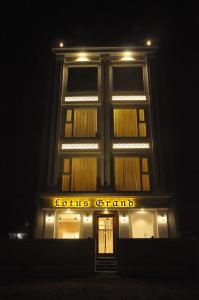 un edificio con un cartel en la parte delantera de la noche en Lotus Grand Akm, en Kālka