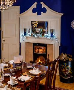 uma sala de jantar com uma mesa e uma lareira em Fauhope Country House em Melrose