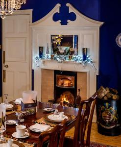 a dining room with a table with a fireplace at Fauhope Country House in Melrose
