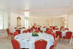 a banquet hall with white tables and red chairs at Château de Lastours in Valence-dʼAgen