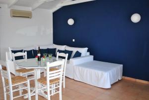 a dining room with a white table and chairs at LIVAS Apartment in Ierápetra