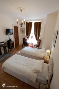 a bedroom with two beds and a living room with a window at Château de Lastours in Valence-dʼAgen