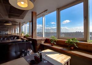a restaurant with large windows and a view of the city at Moscow Hotel in Saint Petersburg