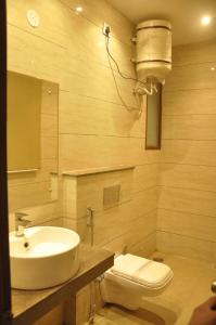 a bathroom with a sink and a toilet at Lotus Grand Akm in Kālka