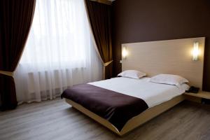 a bedroom with a large bed and a large window at Bed & Breakfast Olsi in Chişinău