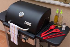 a grill with red scissors and bottles of wine at Matarolux 1 in Mataró