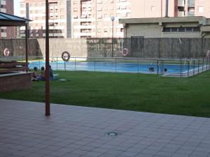 ログローニョにあるApartamentos Sarabiaの公園の芝生に座る人々のいるプール