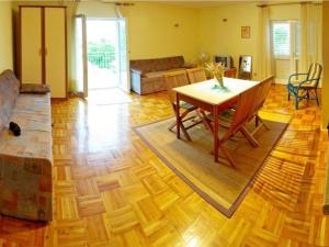 salon z drewnianą podłogą i stołem w obiekcie Apartments & Rooms Boris w Sukošanie