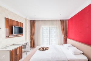 a bedroom with a large bed with a red wall at Hotel Dosco in Van