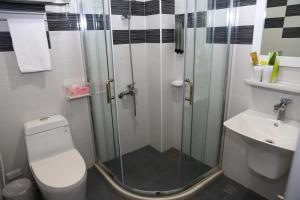 a bathroom with a shower and a toilet and a sink at 500Km Home in Hualien City