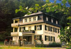Una casa grande con un cartel que dice que le gusta una actualización en Pension "Haus am Walde" Brodenbach, Mosel, en Brodenbach