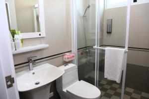 a bathroom with a toilet and a sink and a shower at 500Km Home in Hualien City