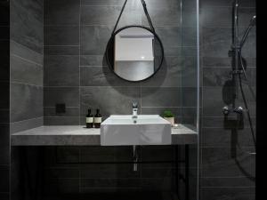 un bagno con lavandino e specchio di Monka Hotel a Taipei