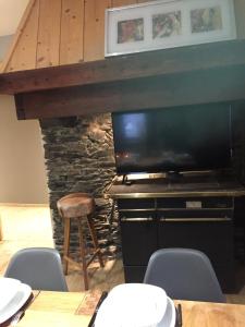 a dining room with a tv and a table with chairs at Le Rocher in Sainte-Foy-Tarentaise