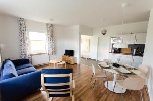 a living room with a blue couch and a table at Ferienwohnung 1 Wildgans in Sagard