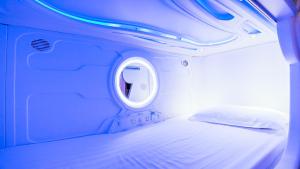 Un pat sau paturi într-o cameră la Spacepod@com
