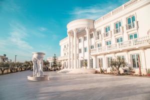 a white building with a vase in front of it at Hotel Villa Pascucci in Durrës