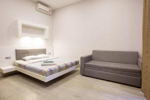 1 dormitorio con 1 cama y 1 sofá en Pushkinskaya Apartments, en Járkov