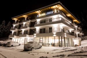 un gran edificio con coches aparcados en la nieve en The Ischgl Lodge, en Ischgl