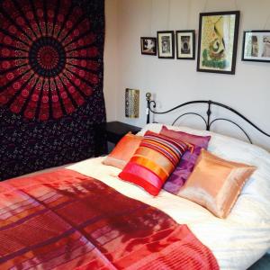 um quarto com uma cama com almofadas coloridas em St Anne's em Glastonbury