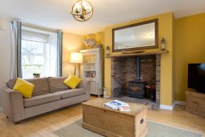 a living room with a couch and a fireplace at Church Cottage by Coast & Country Stays in Beadnell