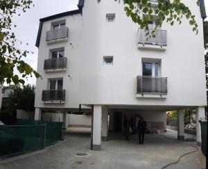 Ein Mann steht vor einem weißen Gebäude. in der Unterkunft Alexys Residence 8 in Iaşi