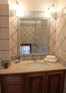 ein Bad mit einem Waschbecken und einem Spiegel in der Unterkunft La Maiolica Maison in Positano