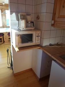 a microwave sitting on top of a counter in a kitchen at Fjellbu Two-bedroom Cottage in Geilo