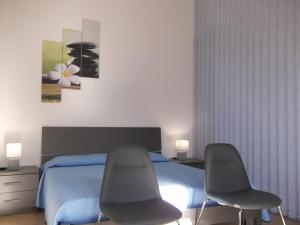 twee stoelen voor een bed in een slaapkamer bij Casa Maria Teresa in Cardedu