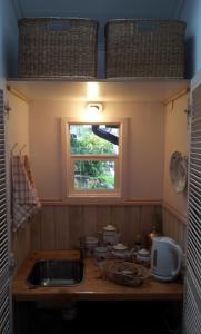 una pequeña cocina con fregadero y ventana en Hotel Serenade de Franz Schubert, en Frutillar