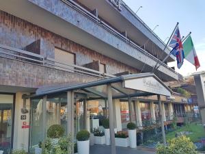 un edificio con due bandiere davanti di Plus Welcome Milano a Milano