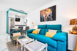 sala de estar con sofá azul y sillas en iloftmalaga Sostoa, en Málaga