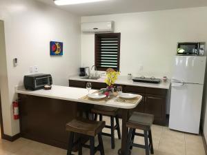 a kitchen with a white refrigerator and a table with chairs at Buccaneer Beach Club in Dickenson Bay