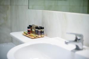 a bathroom with a sink and a mirror and a toothbrush holder at Congo Palace in Athens