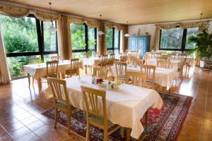 a dining room with tables and chairs and windows at Haus BEER in Bad Tölz
