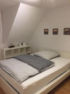 a white bed in a room with a roof at Ferien- Monteurswohnung in Brunsbüttel