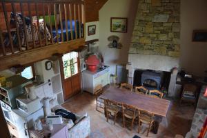 a living room with a wooden table and a fireplace at LA FERME des DAIMS in Saint-Quay-Perros