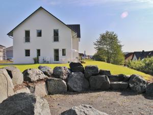 a house with a bunch of rocks in front of it at FeWo WELL in Gladenbach