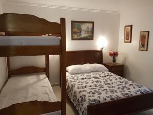 1 Schlafzimmer mit 2 Etagenbetten und 1 Bett mit einer Tagesdecke in der Unterkunft Pousada Princesa in Arraial do Cabo
