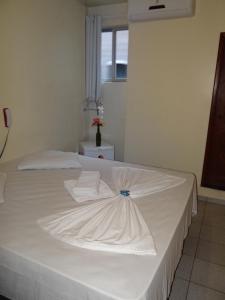 Una cama blanca con dos almohadas encima. en Hotel Transbrasil en Belém