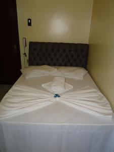uma cama branca com uma camisa branca em Hotel Transbrasil em Belém