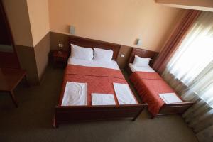 due letti in una camera d'albergo con finestra di Hotel Atlas a Novi Pazar