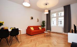 شقق ريهوروفا في براغ: غرفة معيشة مع أريكة حمراء وطاولة