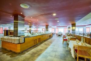 a restaurant with a bar with tables and chairs at SBH Taro Beach Hotel in Costa Calma