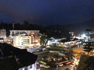 a city lit up at night with buildings and cars at ATS Cameron Hotel & Apartments in Cameron Highlands